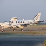 Florida, United States: A twin-engine Beechcraft King Air aircraft carrying 11 people crashed into the Atlantic Ocean off Florida’s east coast on May 12 after the pilot declared an in-flight emergency, triggering a large multi-agency rescue operation that ended with all occupants being recovered alive, according to updated statements from U.S. and Bahamian authorities. The aircraft was operating a regional flight in the Bahamas and had departed Marsh Harbour Airport in Abaco bound for Grand Bahama International Airport in Freeport when the emergency unfolded. Authorities said the aircraft went down roughly 50 miles east of Vero Beach and about 80 miles off Melbourne, Florida, in waters where deteriorating weather conditions were reported at the time. Initial information released by the U.S. Coast Guard stated that 10 people had been rescued, but officials later corrected the figure to 11 after completing accountability procedures for everyone onboard. According to the Bahamas Aircraft Accident Investigation Authority (AAIA), the pilot declared an emergency with air traffic control before communication with the aircraft was lost. Officials have not disclosed the exact nature of the emergency call, and investigators have not yet determined what caused the aircraft to crash into the ocean. No distress details involving engine failure, fire, fuel exhaustion or structural issues have been officially confirmed at this stage. The U.S. Coast Guard Southeast District coordinated the rescue effort after receiving the emergency alert. Rescue assets included a Coast Guard HC-144 Ocean Sentry/C-27 surveillance aircraft along with helicopters and support from maritime rescue agencies. Search crews located survivors in the water and recovered all 11 occupants before transporting them to Florida for medical evaluation. Authorities said several survivors were taken to Holmes Regional Medical Center in Melbourne, while others received treatment at nearby facilities. Officials have not released detailed injury information, but early reports indicated that no fatalities occurred during the accident. Weather conditions are expected to form a major part of the investigation. Meteorological reports from the region indicated unstable conditions along Florida’s east coast and northern Bahamas, including thunderstorms, gusty winds, heavy rain activity and rapidly changing visibility. The aircraft involved has been identified as a Beechcraft 300 King Air series twin-turboprop aircraft, a model widely used across the Caribbean and Bahamas for charter, medical evacuation and inter-island transportation because of its range and short-runway capability. Investigators from both the Federal Aviation Administration (FAA) and Bahamian aviation authorities are now examining the circumstances surrounding the crash. The probe is expected to include analysis of maintenance records, pilot qualifications, air traffic control communications, survivor interviews, weather data and any recoverable wreckage from the crash site. Officials have also not confirmed whether the aircraft remained intact after impact or whether it sank immediately following the ditching. The incident drew widespread attention because of the successful survival and rescue of all occupants despite the aircraft going down far offshore.