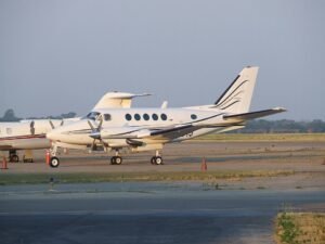 Florida, United States: A twin-engine Beechcraft King Air aircraft carrying 11 people crashed into the Atlantic Ocean off Florida’s east coast on May 12 after the pilot declared an in-flight emergency, triggering a large multi-agency rescue operation that ended with all occupants being recovered alive, according to updated statements from U.S. and Bahamian authorities. The aircraft was operating a regional flight in the Bahamas and had departed Marsh Harbour Airport in Abaco bound for Grand Bahama International Airport in Freeport when the emergency unfolded. Authorities said the aircraft went down roughly 50 miles east of Vero Beach and about 80 miles off Melbourne, Florida, in waters where deteriorating weather conditions were reported at the time. Initial information released by the U.S. Coast Guard stated that 10 people had been rescued, but officials later corrected the figure to 11 after completing accountability procedures for everyone onboard. According to the Bahamas Aircraft Accident Investigation Authority (AAIA), the pilot declared an emergency with air traffic control before communication with the aircraft was lost. Officials have not disclosed the exact nature of the emergency call, and investigators have not yet determined what caused the aircraft to crash into the ocean. No distress details involving engine failure, fire, fuel exhaustion or structural issues have been officially confirmed at this stage. The U.S. Coast Guard Southeast District coordinated the rescue effort after receiving the emergency alert. Rescue assets included a Coast Guard HC-144 Ocean Sentry/C-27 surveillance aircraft along with helicopters and support from maritime rescue agencies. Search crews located survivors in the water and recovered all 11 occupants before transporting them to Florida for medical evaluation. Authorities said several survivors were taken to Holmes Regional Medical Center in Melbourne, while others received treatment at nearby facilities. Officials have not released detailed injury information, but early reports indicated that no fatalities occurred during the accident. Weather conditions are expected to form a major part of the investigation. Meteorological reports from the region indicated unstable conditions along Florida’s east coast and northern Bahamas, including thunderstorms, gusty winds, heavy rain activity and rapidly changing visibility. The aircraft involved has been identified as a Beechcraft 300 King Air series twin-turboprop aircraft, a model widely used across the Caribbean and Bahamas for charter, medical evacuation and inter-island transportation because of its range and short-runway capability. Investigators from both the Federal Aviation Administration (FAA) and Bahamian aviation authorities are now examining the circumstances surrounding the crash. The probe is expected to include analysis of maintenance records, pilot qualifications, air traffic control communications, survivor interviews, weather data and any recoverable wreckage from the crash site. Officials have also not confirmed whether the aircraft remained intact after impact or whether it sank immediately following the ditching. The incident drew widespread attention because of the successful survival and rescue of all occupants despite the aircraft going down far offshore.