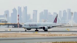 Doha, Qatar: Qatar Airways posted a net profit of QAR 7.08 billion ($1.94 billion) for the 2025/26 financial year, overcoming one of the most challenging operating environments faced by Gulf carriers in recent years as regional conflict disrupted air travel across the Middle East. The airline group’s annual earnings declined more than 7% compared with the previous fiscal year, when it had reported a record QAR 7.8 billion ($2.1 billion) profit. However, the latest results still rank among the strongest in the carrier’s history, reflecting resilient passenger demand, strong cargo performance, and operational stability despite widespread geopolitical disruption. The state-owned airline said the financial year ending March 31, 2026, was heavily impacted during its final quarter by escalating regional tensions linked to the Iran conflict, which triggered temporary airspace closures, flight diversions, schedule disruptions, and higher operating costs across the Gulf aviation sector. The crisis forced airlines throughout the region to cancel thousands of flights and reroute aircraft, creating the most significant operational disruption for Middle Eastern carriers since the COVID-19 pandemic. Despite those challenges, Qatar Airways carried more than 41.8 million passengers during the fiscal year through its Doha hub at Hamad International Airport. Passenger traffic was slightly lower than the 43.1 million travelers recorded a year earlier, reflecting the impact of regional instability during the final months of the reporting period. Cargo operations remained a major contributor to the airline’s financial performance. Qatar Airways Cargo transported more than 1.43 million tonnes of chargeable freight during the year and maintained a 12% share of the global air cargo market, reinforcing its position as one of the world’s largest international freight carriers. Chief Executive Officer Hamad Al-Khater described the financial year as a period that tested both the airline’s commercial strength and operational resilience. He said the company’s performance demonstrated the strength of its balance sheet, partnerships, and workforce despite operating under “genuine pressure” during the regional crisis. The airline said approximately 57,800 employees across more than 90 countries supported operations throughout the crisis period, particularly during the final weeks of the financial year when regional airspace disruptions intensified. Operationally, Qatar Airways maintained an on-time performance rate of 86%, placing it among the world’s top five most punctual airlines, according to Cirium rankings. The carrier also received the Cirium Platinum Award for Operational Excellence during the reporting period. The airline continued expanding its long-haul connectivity and technology offerings during the fiscal year. Qatar Airways said it now operates the world’s largest Starlink-equipped widebody fleet, with onboard high-speed internet services available on Boeing 777, Airbus A350, and Boeing 787-8 aircraft. In one of the aviation industry’s biggest fleet commitments, the airline group also signed agreements with Boeing and GE Aerospace covering up to 210 aircraft and 400 engines. The agreements are among the largest widebody aircraft and engine deals in commercial aviation history. The airline is now focused on rebuilding capacity and restoring network connectivity following the regional disruptions. Executives said Qatar Airways plans to expand its network to more than 160 destinations by summer 2026 as Gulf carriers gradually restore schedules impacted by the conflict.