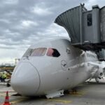 Frankfurt, Germany: A Lufthansa Boeing 787-9 Dreamliner suffered a nose landing gear collapse while parked at a gate at Frankfurt Airport on June 4, 2026, injuring several crew members and ground staff and forcing the cancellation of a scheduled flight to Los Angeles. The aircraft involved was Lufthansa flight LH450 from Frankfurt to Los Angeles, operated by Boeing 787-9 Dreamliner D-ABPQ, named "Herne." The incident occurred at approximately 12:45 p.m. local time while the aircraft was being prepared for departure and was still connected to the passenger boarding bridge. According to Lufthansa, passengers had not yet boarded the aircraft when the collapse occurred. However, crew members and ground personnel were onboard carrying out pre-departure preparations. Several employees sustained injuries and received medical treatment. The airline has not disclosed the exact number of injured personnel or the severity of their injuries. Video footage captured by airport cameras and widely circulated on social media shows the aircraft's nose suddenly dropping to the ground as the forward landing gear unexpectedly folded. Emergency vehicles responded quickly and surrounded the aircraft shortly after the incident. Images from the scene indicate substantial damage to the nose section of the Dreamliner. The aircraft came to rest with its forward fuselage on the apron after the nose landing gear collapsed. The impact reportedly damaged the nose gear bay doors and surrounding structural components. Some reports also suggested that parts of the aircraft's lower fuselage and associated structures may have contacted the ground during the collapse. The Boeing 787-9 involved is one of Lufthansa's newest long-haul aircraft. Flight-tracking data shows the aircraft was delivered to Lufthansa in January 2025 and entered commercial service in February 2025. Since entering service, it had completed approximately 137 flights before the incident. Lufthansa confirmed that an investigation has been launched in coordination with the relevant authorities. Boeing stated that it is aware of the event and is supporting the airline during the investigation. At present, investigators have not determined the cause of the collapse. Aviation experts note that a nose landing gear failure while an aircraft is stationary at a gate is extremely uncommon. The investigation is expected to focus on maintenance records, landing gear system components, hydraulic systems, and any maintenance procedures that may have been conducted before departure. Lufthansa aircraft appear to show the nose gear folding forward rather than collapsing under landing loads, leading to a possibility that an unintended gear retraction event could have occurred. Nevertheless, investigators have not confirmed any such scenario, and the exact sequence of events remains under examination. The scheduled Los Angeles service was cancelled as investigators began examining the aircraft and gathering evidence to determine what caused the unexpected failure. Lufthansa said it is continuing to work with authorities to establish the exact circumstances surrounding the incident.