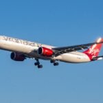 Shannon, Ireland: A Virgin Atlantic Airbus A330-900neo operating a scheduled service from London Heathrow to Montego Bay, Jamaica, made an emergency diversion to Shannon Airport in Ireland on May 30 after suffering an in-flight engine malfunction while crossing the North Atlantic. Flight VS165 departed London Heathrow at approximately 1604 UTC and was operating normally at cruising altitude when the crew encountered a problem involving the aircraft’s right-hand Rolls-Royce Trent 7000 engine nearly three hours into the transatlantic crossing. The aircraft, registered G-VTOM, was cruising at Flight Level 360 approximately 440 nautical miles west of Shannon when the right-hand engine experienced a stall. The flight crew subsequently reduced the engine to idle thrust and initiated diversion procedures. The aircraft then descended to Flight Level 200 and turned back toward Ireland. The Airbus A330-900 was carrying 246 passengers and 13 crew members at the time of the incident. With several hours of oceanic flight remaining to Montego Bay, the crew elected to continue on a single-engine profile and divert to the nearest suitable airport. Air traffic controllers coordinated the diversion to Shannon Airport, a major transatlantic emergency diversion facility frequently used by long-haul aircraft operating across the North Atlantic. Emergency response procedures were activated ahead of the aircraft’s arrival. The aircraft landed safely at Shannon at approximately 2124 local time after roughly five hours of flight. Emergency vehicles accompanied the aircraft during landing and rollout. Following a brief inspection by emergency personnel on the runway, no signs of fire or immediate hazards were detected, allowing the aircraft to taxi to a parking stand. All passengers and crew members disembarked safely. No injuries were reported. Passenger accounts provided additional insight into the event. Jamaican attorney Yushaine Morgan, who was travelling onboard the flight, told local media that passengers heard a loud bang approximately three hours after departure. He said a smell of smoke was detected in the cabin and that the captain subsequently informed passengers of an engine failure and the need to divert. Virgin Atlantic confirmed the diversion, describing it as a precautionary measure following a technical issue involving the aircraft. The airline did not officially disclose the exact nature of the malfunction. A spokesperson said the aircraft landed safely and apologised for the disruption caused to passengers. The airline arranged a replacement aircraft and provided accommodation, rebooking options, alternative travel arrangements, and refund options for affected customers. Following arrival in Shannon, passengers reportedly remained at the airport for several hours before being transported back to London Heathrow on a replacement aircraft. Some passengers were subsequently rebooked on later services to Jamaica, subject to seat availability. The incident is expected to be reviewed by Virgin Atlantic engineers and relevant aviation authorities. Investigators will examine flight data, engine performance information, maintenance records, and any onboard indications recorded during the event to determine the precise cause of the malfunction. The aircraft remained in Shannon following the diversion while technical inspections were carried out.
