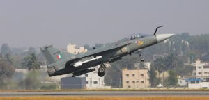 HAL Files Cheating & Forgery Case Over Fake Test Reports In Tejas Mk1A Supply Chain SEO DES: The case covers 2022–23 procurement of 172 parts across 35 categories; HAL found discrepancies in checks, and a lab denied issuing several certificates SOCIAL: HAL has filed a cheating and forgery case against a Hyderabad-based supplier over alleged 199 forged test reports linked to Tejas Mk1A aircraft components. The FIR names Tec Aero Devices and its CEO. The case covers 2022–23 procurement of 172 parts across 35 categories. HAL detected discrepancies during quality checks, and a lab reportedly denied issuing several certificates. HAL lodged a complaint in Bengaluru, debarred the supplier for three years, and confirmed no payments were made. The matter is under investigation. Image: Government of India (Wikimedia) Video: Bengaluru, India: Hindustan Aeronautics Limited (HAL) has filed a cheating and forgery case against a Hyderabad-based aerospace supplier over allegations that it submitted forged material test reports linked to components used in the Light Combat Aircraft (LCA) Tejas Mk1A programme. According to official complaints, HAL’s Aircraft Division has named Tec Aero Devices and its CEO M. Sivarama Prasad in the FIR, accusing them of cheating, criminal conspiracy, and forgery under relevant provisions of the Indian Penal Code. The case relates to procurement orders placed between March 2022 and September 2023 for 35 categories of components and 172 individual parts supplied for the indigenous fighter aircraft programme. HAL has alleged that the supplier submitted as many as 199 forged material test reports covering critical aerospace-grade components. These reports were reportedly linked to key testing parameters including tensile strength, hardness, shear load, corrosion resistance, and non-destructive testing. The discrepancies came to light during routine quality assurance checks conducted by HAL, which triggered a deeper internal review of the certification documents submitted by the vendor. As part of the investigation, HAL conducted verification with the laboratory mentioned in the test certificates. The lab reportedly denied issuing several of the documents attributed to it, stating that its name and credentials had been misused. This confirmation strengthened suspicions that the test reports were fabricated and not generated through authorised testing procedures. Following internal findings, HAL lodged a formal complaint with the HAL police station in Bengaluru, leading to the registration of an FIR. The case includes charges of cheating, forgery, forgery for the purpose of cheating, and criminal conspiracy. HAL has also initiated internal procurement action against the supplier, including issuing a show-cause notice and imposing a three-year debarment, barring the company from participating in future contracts until March 2027. Officials further confirmed that no payments were released for the disputed supplies, thereby limiting financial exposure. The incident has raised concerns over supply chain integrity within India’s defence manufacturing ecosystem, particularly in relation to the Tejas Mk1A programme, which is central to the Indian Air Force’s modernisation plans. The Light Combat Aircraft Mk1A is a key indigenous fighter platform under large-scale production, and stringent quality assurance is critical for ensuring airworthiness and operational safety. While HAL has not issued further comments beyond confirming the complaint and ongoing cooperation with authorities, the matter is now under police investigation. The case comes amid increased scrutiny of defence procurement processes and quality control mechanisms in high-value indigenous aerospace programmes. Investigators are expected to determine whether the alleged forgery was an isolated supplier-level issue or part of a broader malpractice within the supply chain.