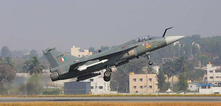 HAL Files Cheating & Forgery Case Over Fake Test Reports In Tejas Mk1A Supply Chain SEO DES: The case covers 2022–23 procurement of 172 parts across 35 categories; HAL found discrepancies in checks, and a lab denied issuing several certificates SOCIAL: HAL has filed a cheating and forgery case against a Hyderabad-based supplier over alleged 199 forged test reports linked to Tejas Mk1A aircraft components. The FIR names Tec Aero Devices and its CEO. The case covers 2022–23 procurement of 172 parts across 35 categories. HAL detected discrepancies during quality checks, and a lab reportedly denied issuing several certificates. HAL lodged a complaint in Bengaluru, debarred the supplier for three years, and confirmed no payments were made. The matter is under investigation. Image: Government of India (Wikimedia) Video: Bengaluru, India: Hindustan Aeronautics Limited (HAL) has filed a cheating and forgery case against a Hyderabad-based aerospace supplier over allegations that it submitted forged material test reports linked to components used in the Light Combat Aircraft (LCA) Tejas Mk1A programme. According to official complaints, HAL’s Aircraft Division has named Tec Aero Devices and its CEO M. Sivarama Prasad in the FIR, accusing them of cheating, criminal conspiracy, and forgery under relevant provisions of the Indian Penal Code. The case relates to procurement orders placed between March 2022 and September 2023 for 35 categories of components and 172 individual parts supplied for the indigenous fighter aircraft programme. HAL has alleged that the supplier submitted as many as 199 forged material test reports covering critical aerospace-grade components. These reports were reportedly linked to key testing parameters including tensile strength, hardness, shear load, corrosion resistance, and non-destructive testing. The discrepancies came to light during routine quality assurance checks conducted by HAL, which triggered a deeper internal review of the certification documents submitted by the vendor. As part of the investigation, HAL conducted verification with the laboratory mentioned in the test certificates. The lab reportedly denied issuing several of the documents attributed to it, stating that its name and credentials had been misused. This confirmation strengthened suspicions that the test reports were fabricated and not generated through authorised testing procedures. Following internal findings, HAL lodged a formal complaint with the HAL police station in Bengaluru, leading to the registration of an FIR. The case includes charges of cheating, forgery, forgery for the purpose of cheating, and criminal conspiracy. HAL has also initiated internal procurement action against the supplier, including issuing a show-cause notice and imposing a three-year debarment, barring the company from participating in future contracts until March 2027. Officials further confirmed that no payments were released for the disputed supplies, thereby limiting financial exposure. The incident has raised concerns over supply chain integrity within India’s defence manufacturing ecosystem, particularly in relation to the Tejas Mk1A programme, which is central to the Indian Air Force’s modernisation plans. The Light Combat Aircraft Mk1A is a key indigenous fighter platform under large-scale production, and stringent quality assurance is critical for ensuring airworthiness and operational safety. While HAL has not issued further comments beyond confirming the complaint and ongoing cooperation with authorities, the matter is now under police investigation. The case comes amid increased scrutiny of defence procurement processes and quality control mechanisms in high-value indigenous aerospace programmes. Investigators are expected to determine whether the alleged forgery was an isolated supplier-level issue or part of a broader malpractice within the supply chain.