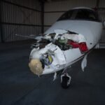 North Carolina, United States: A corporate business jet collided with a box truck while taxiing at Raleigh-Durham International Airport (RDU) in North Carolina on Wednesday afternoon, temporarily shutting down the airport's airfield, disrupting flight operations and prompting an investigation by federal authorities. The incident occurred on Taxiway C at approximately 2 p.m. local time on July 1, according to airport officials. The aircraft involved has been identified as a Nicholas Air Embraer EMB-500 Phenom 100 business jet, registered as N356N and operating as JTZ356, aviation records show. Airport officials confirmed that two occupants aboard the aircraft and the lone driver of the box truck escaped without injuries. Images from the scene showed the aircraft sustaining significant damage to its nose section, while emergency responders quickly secured the area following the collision. The damaged aircraft was later moved into a hangar as investigators began examining the incident. The accident forced RDU to close its airfield for nearly an hour, halting arriving and departing traffic before operations resumed at around 2:30 p.m. Airport spokesperson Stephanie Hawco confirmed that the airfield was reopened after emergency crews cleared the taxiway and determined it was safe to resume operations. Although the closure was brief, it caused widespread disruption across the airport's flight schedule. According to airport officials and flight tracking data, between 15 and 20 flights were diverted or delayed. Several inbound aircraft were rerouted to Charlotte Douglas International Airport, while others diverted to Greensboro and Washington Dulles International Airport. A Copa Airlines service originally bound for Raleigh was among the flights diverted to Dulles. Charlotte Douglas Airport later confirmed that six diverted aircraft were expected to refuel before returning to RDU. The disruption also affected departing passengers. A scheduled international flight to Germany departed approximately three hours late, while travelers reported extended waits as the temporary closure created a ripple effect across the airport's operations. One passenger told WRAL that he considered driving to Greensboro after his daughter's incoming flight was diverted but was later informed that the aircraft would eventually return to Raleigh. During the same period, airport officials also handled an unrelated event involving an incoming aircraft that reported a possible mechanical issue. The aircraft landed safely and was not connected to the taxiway collision. Flight instructor Steve Welsh told WRAL that aircraft generally have the right of way on taxiways and noted that business jets possess significant blind spots, making strict coordination between aircraft and ground vehicles essential. "In incidents where a vehicle hits an aircraft, the aircraft always has the right of way," Welsh said, adding that vehicles approaching from the side may not become visible to pilots until they are very close to the aircraft. RDU later issued a statement confirming normal operations had resumed. "RDU closed the airfield briefly earlier this afternoon after a general aviation aircraft and a box truck collided on a taxiway. There were no injuries, and the airfield has reopened to arriving and departing flights." Videos shared by witnesses on social media showed emergency vehicles surrounding the damaged aircraft while airport operations remained suspended during the response. According to airport statistics, Raleigh-Durham International Airport handles approximately 360 daily arrivals and departures served by 17 airlines. The airport recorded 5.6 million passengers in 2025, marking its busiest year on record. The National Transportation Safety Board (NTSB) has launched an investigation into the collision. Authorities have not yet determined the cause, and it remains unclear whether the incident resulted from pilot actions, vehicle operations, airport procedures or another contributing factor.