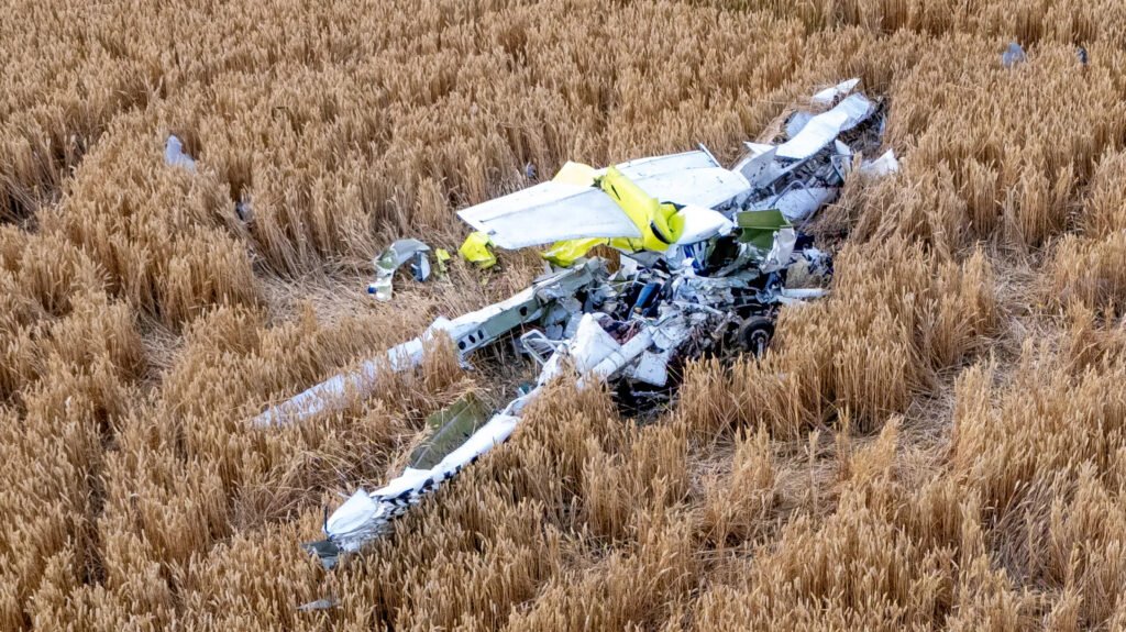 Ongar, United Kingdom: Two people were killed after a light aircraft crashed into a field near High Ongar in Essex shortly after departing North Weald Airfield on what authorities described as a "short flight experience," prompting a multi-agency emergency response and a formal investigation by the UK's Air Accidents Investigation Branch (AAIB). The aircraft, a Cessna 152, came down in farmland off Mill Lane, High Ongar, at approximately 12:30 p.m. BST on Tuesday, June 30. Emergency services were called to the scene shortly after the crash, but both occupants were pronounced dead. Essex Police confirmed that the victims died at the scene. As of the latest official update, authorities have not publicly identified either individual, stating that formal identification procedures and notifications to their next of kin remain ongoing. According to Essex Police, the aircraft had departed from North Weald Airfield shortly before the accident for what was described as a short flight experience. Flight-tracking data from Flightradar24, cited by several British media outlets, shows the aircraft departed at approximately 12:22 p.m. The aircraft initially flew east before making a turn back toward North Weald. Roughly eight minutes after take-off, the aircraft disappeared from radar at around 12:30 p.m., coinciding with the reported crash time. The flight path indicates the aircraft remained relatively close to the departure airfield throughout the flight. Flightradar24 data further indicated that the same aircraft had completed two flights earlier on the day of the accident and had flown five separate flights the previous day, suggesting it had been conducting multiple local experience or training flights. Authorities have not stated whether the accident occurred while the aircraft was attempting to return to North Weald or whether the return track reflected the planned flight profile. The aircraft came down in an agricultural field near Mill Lane in High Ongar, a rural village northeast of North Weald. Images from the crash site showed extensive damage to the aircraft, which came to rest in the field following impact. Emergency services secured the area while investigators began documenting the wreckage. Police established cordons around the crash site, restricting access as specialist investigators examined the wreckage. Authorities have not disclosed whether a fire followed the impact, nor have they released any preliminary findings regarding the aircraft's attitude, speed or configuration before the crash. Essex Police coordinated the emergency response alongside: Essex County Fire and Rescue Service East of England Ambulance Service Air ambulance resources Air Accidents Investigation Branch (AAIB) Emergency crews arrived shortly after receiving reports of the crash. Despite their efforts, both occupants were confirmed deceased at the scene. The police subsequently appealed for witnesses and requested that anyone who may have seen the aircraft before the accident or captured photographs, video footage or dashcam recordings contact investigators. The Air Accidents Investigation Branch (AAIB) launched a formal investigation immediately after the accident. The agency confirmed that it dispatched a multidisciplinary team consisting of specialists in: Aircraft operations Engineering Human factors Recorded data and evidence collection Investigators began examining the wreckage, documenting the accident site and collecting physical evidence. The AAIB has not released any preliminary findings, and investigators have emphasized that it is too early to determine the cause of the accident. No indication has been given that mechanical failure, pilot actions, weather or any other factor contributed to the crash. Those questions remain under investigation. A preliminary AAIB report is expected in due course, while a comprehensive final report may take many months to complete. Authorities have confirmed only that two people were on board the aircraft. Although police described the flight as a "short flight experience," they have not officially confirmed the identities or roles of the occupants, including whether one was an instructor and the other a passenger or trial-flight participant. Their names, ages and hometowns have not yet been released publicly. Police stated that specialist officers are supporting the families while formal identification procedures continue.