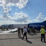 Bishkek, Kyrgyzstan: A TezJet McDonnell Douglas MD-83 carrying 181 people suffered a dramatic landing gear collapse during its takeoff roll at Manas International Airport in Bishkek, Kyrgyzstan, on Tuesday, July 7, forcing an emergency evacuation and temporarily shutting down the country's busiest airport. All passengers and crew escaped safely, with no fatalities or serious injuries reported, although several occupants sustained minor cuts, bruises and abrasions while evacuating via emergency slides. The aircraft was operating scheduled domestic flight K9117 from Bishkek to Osh when its left main landing gear collapsed while accelerating for departure on Runway 26. Airport authorities said the pilots were able to reject the takeoff because the aircraft was still travelling at a relatively low speed. After coming to a stop, the aircraft leaned sharply onto its left side, causing the left wing to scrape the runway and rupture, resulting in a jet fuel leak. Emergency crews, including airport firefighters, responded immediately as fuel spilled onto the runway. Despite the leak, there were no reports of a post-incident fire. The flight crew initiated an emergency evacuation using inflatable escape slides, allowing all 181 including 152 adults, 11 teenagers, and 18 children occupants to leave the aircraft safely. Authorities said several passengers suffered minor abrasions, cuts and bruises during the evacuation, but none required treatment for life-threatening injuries. No official breakdown of passengers by adults, children or infants has been released. Images from the scene showed extensive damage to the MD-83. The aircraft came to rest tilted onto its left wing, while the lower empennage (tail section) was torn away during the incident. Debris and spilled fuel were visible around the aircraft as emergency personnel secured the area. According to the state airport operator, Airports of Kyrgyzstan, Manas International Airport was temporarily closed following the occurrence while emergency responders removed the aircraft and ensured the runway was safe for operations. The airport later began restoring normal flight movements after the scene was secured. The aircraft involved was a McDonnell Douglas MD-83, a twin-engine narrow-body airliner from the MD-80 family. Aviation Safety Network identified the aircraft as operating TezJet Flight K9117 and reported that the incident occurred during the takeoff roll after the left-hand main landing gear collapsed. The MD-80 family, introduced in the 1980s, continues to serve with a limited number of operators worldwide despite its age. As of publication, neither TezJet nor Kyrgyz aviation authorities have announced the cause of the landing gear failure. An investigation has been launched to determine what led to the collapse, and investigators are expected to examine the aircraft's landing gear system, maintenance records and flight data before issuing preliminary findings.