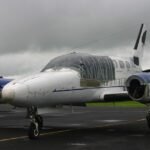 Alaska, United States: A twin-engine Cessna 441 charter aircraft carrying eight people crashed near the remote Cape Newenham Long Range Radar Site in western Alaska on Thursday, August 20, while approaching Cape Newenham. The aircraft, operated by Security Aviation, had departed Ted Stevens Anchorage International Airport and was headed to Cape Newenham when it went down west of Cape Newenham LRRS Airport at about 12:15 p.m. local time. NTSB Alaska region chief Clint Johnson confirmed that two pilots and six passengers were aboard, but officials had not released their condition or confirmed any fatalities or survivors at the time of reporting. The Alaska Rescue Coordination Center launched a search-and-rescue mission after receiving a report of an “aircraft incident” near the Cape Newenham Long Range Radar Site. Johnson, the NTSB’s Alaska region chief, provided the passenger and crew count to The Associated Press and said he did not immediately have details on the status of those aboard. AP reported that Johnson said the aircraft was believed to have crashed early Thursday afternoon while on approach to Cape Newenham. “The information received so far is preliminary,” Johnson said. According to the FAA, the aircraft crashed west of Cape Newenham LRRS Airport at 12:15 p.m. local time. The Cessna 441 is a twin-engine turboprop aircraft. Security Aviation, an Anchorage-based charter operator, lists the Cessna 441 Conquest II among its fleet and says the aircraft is suited for operations across Alaska, including airports with gravel runways and challenging weather and airport environments. The aircraft was believed to have gone down during its approach to Cape Newenham rather than after landing. However, authorities have not disclosed what caused the aircraft to crash, whether the crew issued an emergency call, whether there was a mechanical problem, or what the weather conditions were at the time of the accident. None of those factors has been identified by investigators as a cause. The crash occurred near the Cape Newenham Long Range Radar Site, a remote facility in western Alaska. The Alaska Rescue Coordination Center said it began a search-and-rescue operation after receiving a report of an “aircraft incident” in the area. Authorities had not publicly confirmed whether rescuers had reached all eight occupants, whether anyone had survived, or whether there were fatalities. NTSB officials also had not released the identities of the pilots or passengers. The lack of information was attributed in part to the remote location of the crash site and the early stage of the response. The NTSB is leading the investigation, with the FAA assisting. Investigators are expected to establish the aircraft’s flight path, examine the wreckage and determine what led to the crash. No cause has been announced, and the NTSB has stressed that the information available so far remains preliminary.
