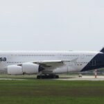 Munich, Germany: A Lufthansa Airbus A380-800 operating flight LH459 from San Francisco International Airport to Munich Airport touched down prematurely near the eastern threshold of Munich’s southern runway on Monday evening, August 17, 2026, damaging runway-threshold lighting. The aircraft, registered D-AIML, was carrying 351 passengers after completing the approximately 11-hour transatlantic flight from San Francisco, United States, to Munich, Germany. All passengers and crew were able to leave the aircraft normally, with no injuries reported. Flight records identify D-AIML as an Airbus A380-841 operated by Lufthansa, while Lufthansa’s published schedule confirms LH459 operates between San Francisco and Munich. According to Lufthansa, the aircraft touched down on the concrete surface before the white-marked runway threshold. During the premature touchdown, the aircraft struck lighting installed around the runway threshold, causing damage to the runway’s visual guidance system. Lufthansa spokesperson Jörg Waber said in a statement, “We can confirm that an AirVIbus A380-800 damaged runway lighting in the area of the runway threshold.” He added that the aircraft had arrived from San Francisco with 351 passengers, subsequently taxied to its assigned position and that all passengers left the aircraft normally. The incident occurred on Munich Airport’s southern runway, identified as Runway 26L when used for approaches from the east. The Deutsche Flugsicherung describes Runway 26L as Munich’s southern runway and says aircraft approaching it from the east use its instrument landing system. Munich Airport characterized the infrastructure damage as minor. According to the airport, a “minor damage” to lighting was identified around the eastern threshold of the southern runway. The damaged lighting was repaired promptly, allowing the runway to return to service less than an hour after the A380 landed. The exact circumstances that caused the A380 to touch down before the designated threshold remain unclear. No official finding has attributed the event to pilot error, weather, aircraft malfunction, runway conditions or any problem with the airport’s approach system. The aircraft touched down short of the marked threshold and that its landing gear struck approach lights. The cause remains under investigation. Germany’s Federal Bureau of Aircraft Accident Investigation, or BFU, has opened an investigation into the occurrence. The A380 involved was approximately 13 years old and carried the registration D-AIML. Flight-history records identify the aircraft as an Airbus A380-841 operated by Lufthansa. The airline’s A380 configuration can accommodate up to 509 passengers, although 351 passengers were onboard LH459 during this particular flight. Separately, on August 15, 2026, a Vietnam Airlines Boeing 787-9 bound for Hanoi experienced an unusually long takeoff run at Munich Airport. The aircraft continued accelerating almost to the end of Runway 26L and reportedly travelled about 120 metres beyond the paved surface before becoming airborne. During the extremely late rotation, its rear underside struck the ground, causing a tailstrike and damage to the aft fuselage. After takeoff, warnings for tail contact and low tyre pressure prompted the crew to remain near Munich at around 9,000 feet for about two hours before returning. The aircraft sustained further landing-gear and tyre damage, with several tyres damaged or deflated, and was unable to taxi after landing. It was carrying 271 passengers and 16 crew, all of whom were reported safe. German authorities are leading the investigation, with Vietnamese investigators assisting, while the cause of the unusually prolonged takeoff remains under investigation.