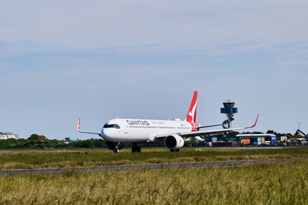 Sydney, Australia: The Australian Transport Safety Bureau (ATSB) has launched an investigation into a serious runway incursion involving two Qantas-operated aircraft at Sydney Airport after an air traffic control clearance resulted in one aircraft being instructed to cross an active runway while another was still landing. The incident occurred on 27 July 2026 at approximately 08:14 local time, and although no collision occurred, the safety watchdog has classified it as a breakdown in coordination and opened a formal investigation. According to the ATSB, the occurrence involved Qantas Flight QF124, a Boeing 737-800 registered VH-XZG, which had arrived from Queenstown, New Zealand, and QantasLink Flight QLK424D, a De Havilland Canada Dash 8 Q400 registered VH-QOC, arriving from Canberra, Australian Capital Territory. Preliminary information released by the ATSB states that after landing on Runway 25, the Boeing 737 was instructed by air traffic control to taxi and cross Runway 34L. At the same time, the Dash 8 Q400 had been cleared to land on Runway 34L and was still completing its landing roll along the active runway. As the Boeing approached the runway crossing point, air traffic controllers recognised the developing conflict. The ATSB said the 737 crew stopped the aircraft before entering Runway 34L, while the Dash 8 continued its landing roll on the runway. Because the Boeing halted short of the runway, the two aircraft remained separated and no collision occurred. No injuries or aircraft damage were reported, and both aircraft subsequently continued normal ground operations. The ATSB has not released the number of passengers or crew on board either flight. The safety bureau has opened investigation AO-2026-086 to determine the factors that led to the runway incursion. Investigators will examine the sequence of air traffic control clearances, coordination between controllers, recorded radio communications, surveillance data, aircraft movements, human factors and operational procedures. The investigation will also assess whether any broader systemic issues contributed to the occurrence. In its initial investigation notice, the ATSB described the event as involving a breakdown of coordination between aircraft movements on intersecting runways. The agency noted that evidence collection is underway, including interviews with relevant personnel and analysis of operational data. A final report is expected before the end of 2026, although the timeline may change depending on investigative findings. The incident has renewed attention on staffing pressures within Australia's air traffic control system. Recent media reports have highlighted controller shortages and increased workload at Sydney Airport, with industry representatives raising concerns over staffing levels. Airservices Australia has acknowledged workforce challenges and said it is recruiting and training additional controllers, while noting that qualification training takes several years before recruits can work independently in complex airspace. Airservices Australia confirmed it is cooperating fully with the ATSB investigation and said safety remains its highest priority. The organisation has not provided further comment while the independent investigation is ongoing. Qantas also confirmed it is assisting the ATSB and stated that both flight crews were operating in accordance with air traffic control instructions issued during the event.