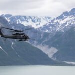 Alaska, United States: Four people were rescued after a Cessna 180 crashed and overturned on a coastal sandbar on Alaska’s Montague Island on August 30, 2026 with Alaska Air National Guard personnel responding to the remote site and transporting all four occupants to a hospital in Anchorage. The crash occurred on a coastal sandbar on Montague Island, about 60 miles southeast of Seward, Alaska, according to the Alaska National Guard. The aircraft was identified as a Cessna 180 carrying four people. The official report did not release the occupants’ names, the aircraft’s registration, the exact flight route or a specific cause of the crash. The rescue operation began after the Alaska Rescue Coordination Center (AKRCC) at Joint Base Elmendorf-Richardson received a signal from the aircraft’s 406 MHz emergency locator transmitter (ELT). The ELT was registered to the owner of the Cessna 180, allowing authorities to identify the aircraft associated with the emergency signal. The people involved in the incident also had a consumer-grade two-way satellite communication device. According to the Alaska National Guard, the device helped maintain the flow of information with the AKRCC and assisted rescuers in obtaining a more precise location of the crash site. Following the alert, the AKRCC requested assistance from the Alaska Air National Guard’s 176th Wing search-and-rescue duty officer. A HH-60W Jolly Green II helicopter from the 210th Rescue Squadron was dispatched with pararescuemen from the 212th Rescue Squadron, commonly known as PJs, aboard. When the rescue team reached the crash site, the Cessna had overturned. Despite its position, the aircraft appeared to be seemingly undamaged, and the four occupants had managed to get themselves out before the pararescuemen reached them. The rescue operation required additional caution because the aircraft had come down on a coastal sandbar. Flying sand and beach debris posed a hazard to the helicopter, so the HH-60W crew landed at a safe distance from the crash site rather than directly next to the occupants. The pararescuemen then made contact with the four people and assessed their condition. One occupant had suffered a back injury. The PJs stabilized the injured person using a vacuum splint and cervical collar before securing the occupant in a Stokes litter for helicopter transportation. The HH-60W crew subsequently flew the injured occupant and the other three people to Providence Alaska Medical Center in Anchorage. They were handed over to civilian medical personnel at the hospital. The Alaska National Guard said the incident also demonstrated the importance of reliable emergency-location and communication equipment during aircraft emergencies in remote areas. AKRCC officials urged aircraft owners to keep their 406 MHz ELT registrations current and encouraged pilots to carry an additional satellite communication device to help speed up rescue operations. The Alaska National Guard reported that all four occupants were rescued from the crash site and transported for medical care. The agency did not provide further information on the occupants’ identities or disclose what caused the Cessna 180 to crash.